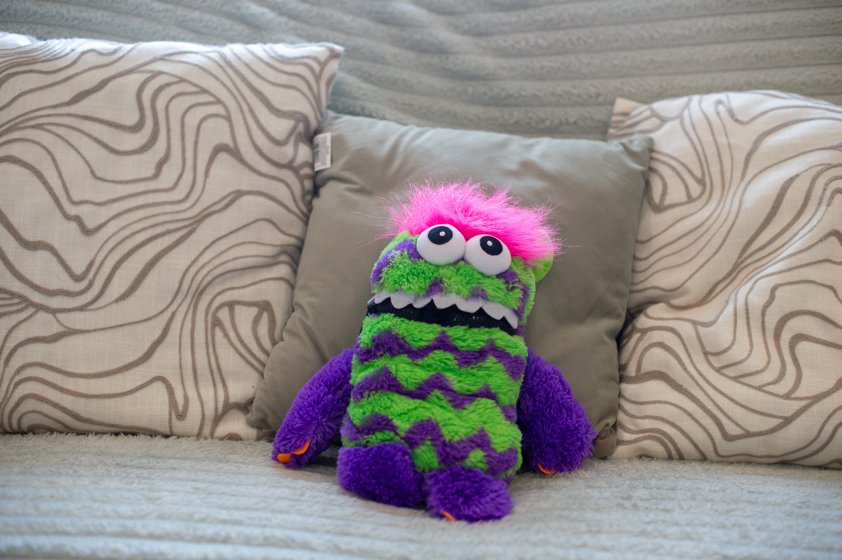 A well-loved soft toy waiting on the sofa